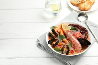 Beyaz ahşap masada servis edilen lezzetli deniz ürünleri çorbası. Metin için boşluk