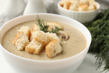 Ekmek arası kremalı leziz mantar çorbası ve dereotu beyaz masada servis edilir.