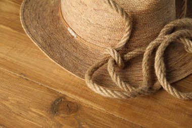 Ahşap arka planda pamuk ip ve hasır şapka, yakın plan.