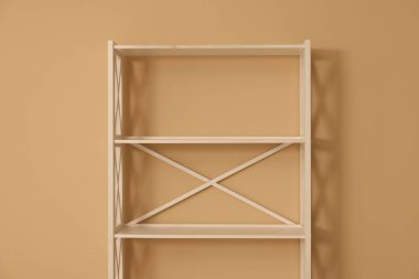 Empty shelving unit near beige wall indoors, closeup