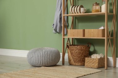 Salon içinde zeytin duvarının yanında farklı dekorasyonu olan ahşap raf ünitesi.