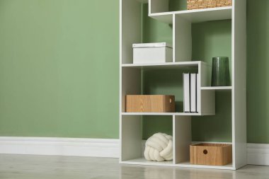 İçerideki zeytin duvarının yanında farklı dekorasyonu olan ahşap raf ünitesi. Metin için boşluk