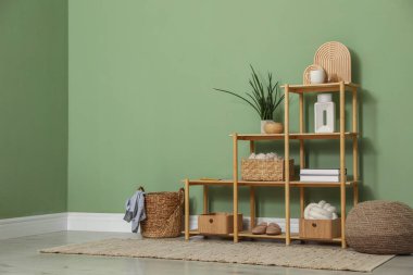 İçerideki zeytin duvarının yanında farklı dekorasyonu olan ahşap raf ünitesi. Metin için boşluk