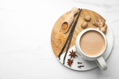 Aromatik Masala çayı, kahverengi şeker ve baharatlar beyaz mermer masa, üst manzara. Metin için boşluk