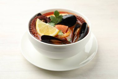 Lezzetli deniz ürünleri çorbası açık ahşap masada, yakın plan.