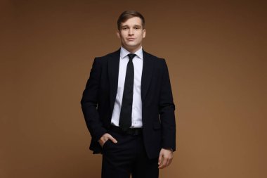 Kahverengi arka planda klasik takım elbiseli adam.