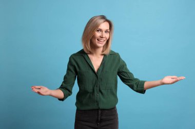 Neşeli kadın açık mavi arka planda konukları karşılıyor.