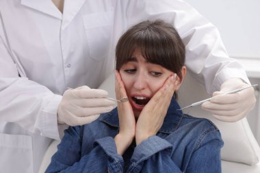 Klinikte dişçiyle randevusu olan korkmuş bir kadın.