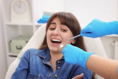 Klinikte dişçiyle randevusu olan korkmuş bir kadın.