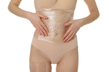 Kadın göbeğine sarılıp beyaz arka plana sarılıyor, yakın plan.