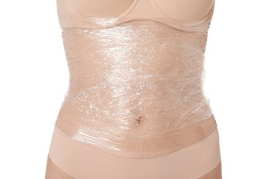 Kadın göbeğine sarılıp beyaz arka plana sarılıyor, yakın plan.