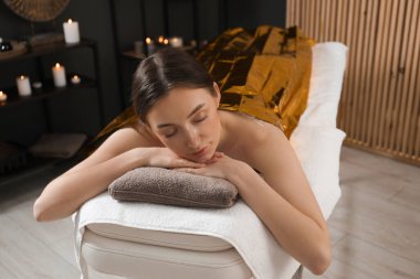 Vücuduna termal folyo örten kadın spa salonunda tedavi görüyor.