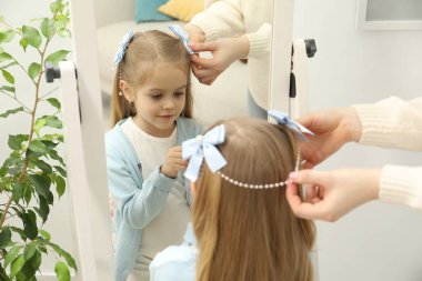 Annem evde kızının saçına sevimli aksesuarlar takıyor.
