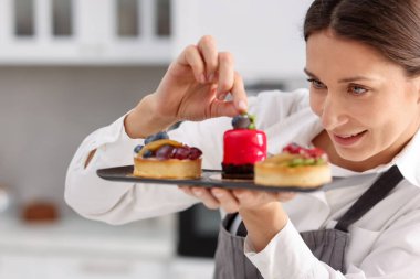 Şekerci mutfakta nane şekeriyle tart süslüyor.