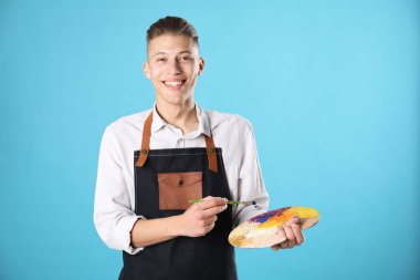 Paletli gülümseyen adam ve açık mavi arka planda fırça.