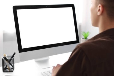 Ofisteki beyaz masada bilgisayarda çalışan bir adam, yakın plan. Tasarım için model