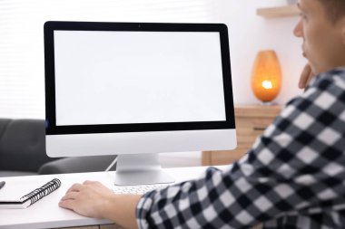 Ofisteki beyaz masada bilgisayarda çalışan bir adam, yakın plan. Tasarım için model