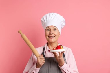 Profesyonel şekerci, tatlı ve pembe arka planda merdane.