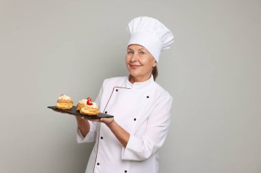 Açık gri arka planı olan profesyonel pasta şefi.