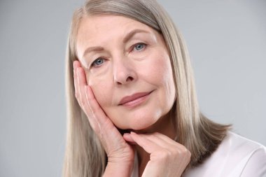 Gri arka planda sağlıklı ciltli kadın, yakın plan.