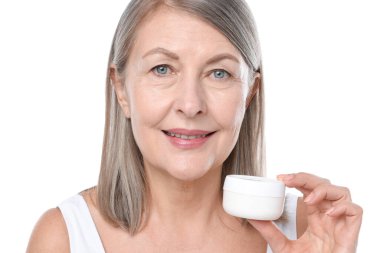 Beyaz arka planda bir kavanoz kolajen kremiyle gülümseyen kadın.