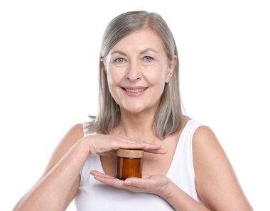 Beyaz arka planda bir kavanoz kolajen kremiyle gülümseyen kadın.