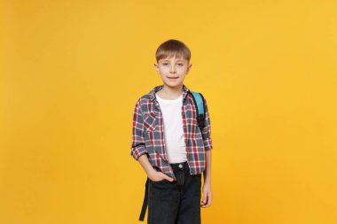 Turuncu arka planda sırt çantası olan tatlı bir okul çocuğu.