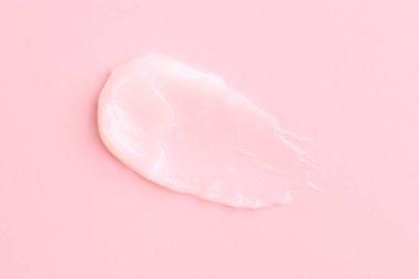 Pembe arka planda nemlendirici dudak kremi, üst manzara.