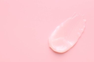 Pembe arka planda nemlendirici dudak kremi, üst manzara. Metin için boşluk