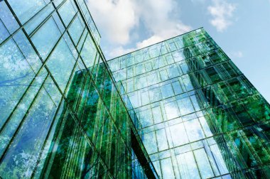 Modern bina ve bereketli ağaçlar, mavi gökyüzüne karşı, çift pozlama. Düşük açı görünümü