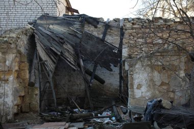 Şiddetli deprem sonrası yıkıntılarla harap olmuş ev ve bahçe.