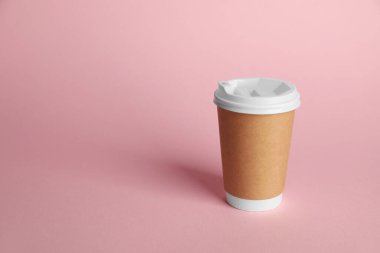 Pembe arka planda bir kağıt bardak. Tasarım için model
