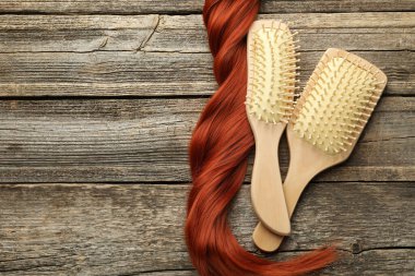 Fırçalar ve bir tutam saç ahşap masada, düz yerde. Metin için boşluk