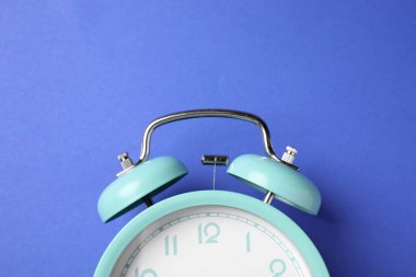 Mavi arkaplanda turkuaz alarm saati, üst görünüm