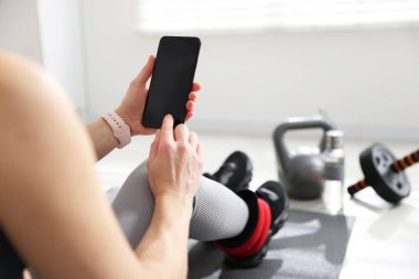 Spor salonunda akıllı telefonu olan kadın, yakın çekim görüntüsü.