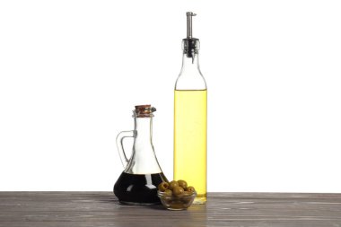 Salata sargıları ve zeytinler beyaz arka plana karşı ahşap masada.