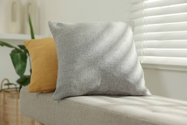 Odadaki kanepede yumuşak dekoratif yastıklar.