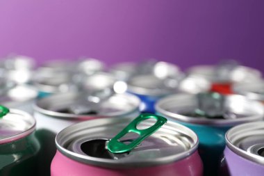 Mor arka planda birçok alüminyum içecek kutusu, yakın plan