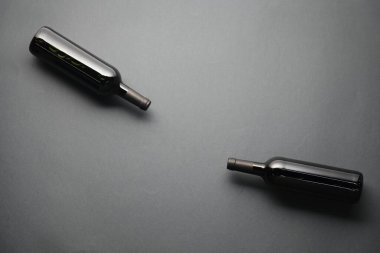 Gri arka planda şarap şişeleri, düz yatış. Metin için boşluk
