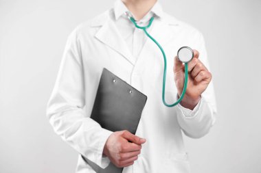 Steteskop ve arkaplanda pano olan doktor, yakın plan.