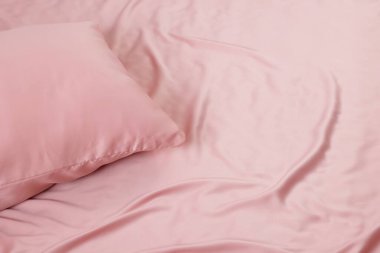 Yatakta güzel pembe ipek çarşaflar, yakın plan. Metin için boşluk