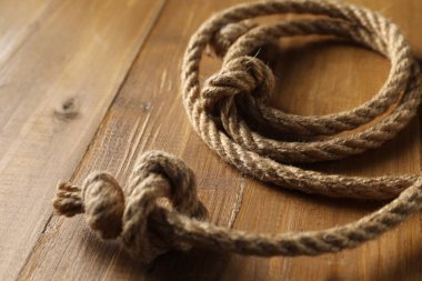 Ahşap arka planda düğümlü pamuk ip, yakın plan