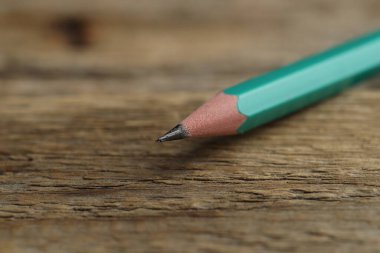 Ahşap masada keskin bir grafit kalem, yakın plan. Metin için boşluk