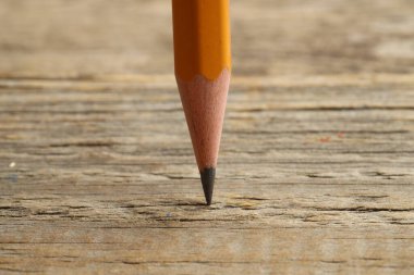 Tahta masada keskin bir grafit kalem, yakın plan.