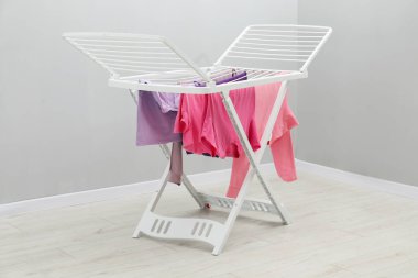 Gri duvarın yanında temiz çamaşırları olan kuru askı.