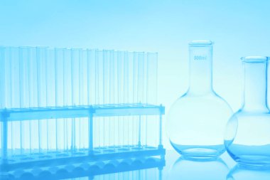 Ayna yüzeyinde açık mavi arkaplana karşı laboratuvar camları