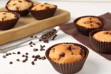 Beyaz ahşap masa üzerinde çikolata parçalı lezzetli kek, yakın plan.