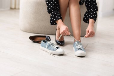 Kadın ayakkabılarını içeride değiştiriyor, yakın plan.