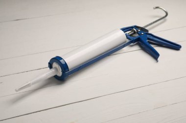 Beyaz ahşap arka planda bir tutkal tabancası