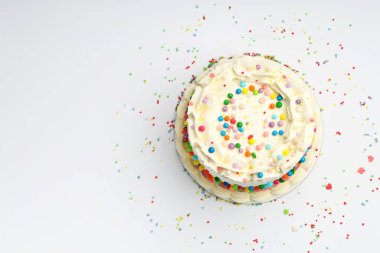 Masanın üstüne renkli şekerlemeler serpiştirilmiş nefis bento keki. Metin için boşluk